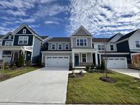 Charming two-story home with a well-manicured lawn, two-car garage and a welcoming teal-colored front door at 328 Catheys Creek Cir, Wendell, NC 27591