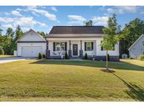 Charming one-story home with a manicured lawn, stone accents, and an inviting front porch at 57 S Shreve Dr, Wendell, NC 27591