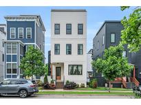 Striking three-story home boasts a contemporary design and professional landscaping at 606 Velma Hopkins Ln, Raleigh, NC 27603
