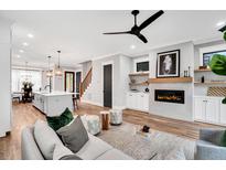 Bright living room with fireplace, open floor plan, and modern ceiling fan at 606 Velma Hopkins Ln, Raleigh, NC 27603