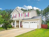 Charming two-story home featuring a two-car garage, red shutters, and well-maintained landscaping at 611 Ashbrittle Dr, Rolesville, NC 27571
