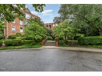 Brick condo building featuring manicured lawns, mature landscaping, and a welcoming walkway at 620 Martin Luther King Jr. Blvd # 302, Chapel Hill, NC 27514
