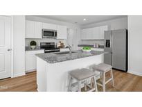 Bright kitchen features granite counters, stainless appliances and a large island with seating at 708 Blazer Bnd, Wendell, NC 27591