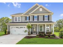 Two-story home with a gray exterior, well-manicured lawn, and a two-car garage at 72 Merle Way, Wendell, NC 27591