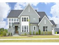 Stunning two-story home showcasing a modern design with a well-manicured lawn and multiple windows at 7736 Roberts Rd, Apex, NC 27523