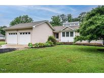 Charming single-story home featuring a well-manicured lawn, front garden, and a two-car garage at 8204 Charlbert Ct, Apex, NC 27539