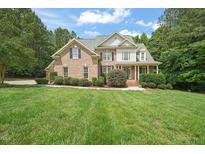 Beautiful brick home with manicured lawn, mature trees, and a welcoming front porch at 85 Pebble Creek Dr, Franklinton, NC 27525