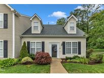Charming home featuring light siding, black shutters, dormer windows and beautiful landscaping at 8611 London Park Ct, Raleigh, NC 27615