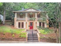 Inviting two-story home with a charming front porch and a well-manicured yard with a red front door at 1008 Dorothea Dr, Raleigh, NC 27603