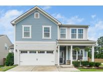 Charming two-story home featuring blue siding, white trim, and a welcoming front porch with rocking chairs at 102 Michelangelo Pl, Morrisville, NC 27560