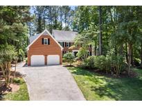 Charming brick home with a two-car garage and lush landscaping at 103 Lochwood West Dr, Cary, NC 27518
