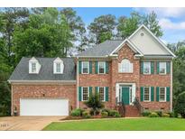 Traditional brick home with green shutters, manicured landscaping, and an attached two-car garage at 103 Rose Sky Ct, Cary, NC 27513