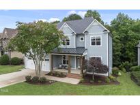 Charming two-story home with a covered front porch and a well-manicured lawn at 106 Painted Turtle Ln, Cary, NC 27519