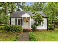 Charming home featuring a welcoming front porch and manicured landscaping at 1105 Hawthorne Ln, Burlington, NC 27215