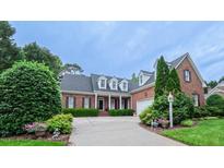 Charming brick home featuring mature landscaping and a welcoming driveway at 119 Georgetowne Dr, Elon, NC 27244