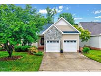 Charming single-story home with stone accents, well-manicured lawn, and a two-car garage at 1216 Miracle Dr, Wake Forest, NC 27587