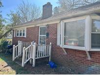 Charming single-story brick home featuring a cozy front porch and a bay window at 1310 Ray Ave, Sanford, NC 27330