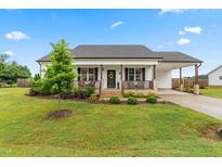Charming single-story home with a well-manicured lawn, covered porch, and convenient carport at 173 Longbow Dr, Middlesex, NC 27557