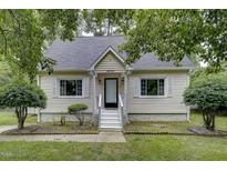 Charming home with white siding, landscaped front yard, and inviting front porch with white stairs at 2012 Stadium Dr, Durham, NC 27705