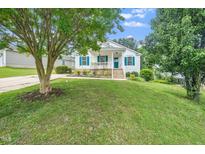 Charming single-story home with vibrant lawn, complemented by mature trees and inviting front porch at 202 Homestead Park Dr, Apex, NC 27502