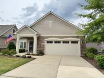 Charming single-Gathering home featuring a stone accent facade, two-car garage and well-manicured lawn at 228 Ellisview Dr, Cary, NC 27519