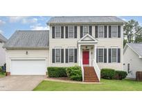 Two-story home featuring classic black shutters, a red front door, and a well-maintained lawn at 2301 Laurel Valley Way, Raleigh, NC 27604