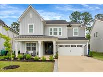 Charming two-story home with gray siding, manicured lawn and a two-car garage at 2426 Heron Watch Pl, Fuquay Varina, NC 27526