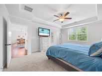 Bright main bedroom with trey ceiling, ceiling fan, TV, and ensuite bath at 247 Axis Deer Ln, Garner, NC 27529