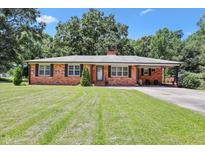 Charming brick home featuring a well-manicured lawn and a covered carport for convenient parking at 28 White Oak Dr, Smithfield, NC 27577