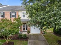 Charming brick and siding townhome featuring a one-car garage and well-maintained landscaping at 2950 Settle In Ln, Raleigh, NC 27614