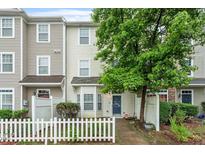 Charming townhome with a white picket fence, mature landscaping, and a welcoming entrance at 300 Gilman Ln # 101, Raleigh, NC 27610