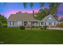 Charming two-story home featuring a well-manicured lawn, inviting front porch, and classic architectural details at 314 Lane Rd, Dunn, NC 28334