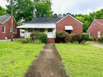 Charming brick home with a covered porch and well-maintained front yard at 3810 Pendergrass St, Durham, NC 27704