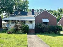 Charming single-story home with a brick and siding exterior, inviting front yard, and covered porch at 3810 Pendergrass St, Durham, NC 27704