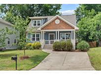 Charming blue craftsman home with a welcoming front porch, manicured landscaping and a paved driveway at 415 Dupree St, Durham, NC 27707