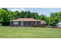 Charming single-story brick home with a well-maintained front yard and mature trees at 424 Camp Rd, Burlington, NC 27217