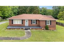 Charming one story brick home with a well-maintained lawn and inviting front porch at 424 Camp Rd, Burlington, NC 27217