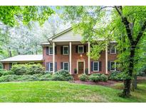 Traditional brick home with a columned porch and well-manicured lawn, exuding Southern charm and elegance at 4521 Chicopee Trl, Durham, NC 27707