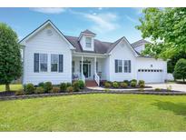 Charming white two-story home with dark shutters, manicured lawn, and beautiful landscaping at 5016 Swordfish Dr, Raleigh, NC 27603