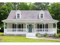 Charming exterior view of home featuring a spacious porch and lovely landscaped yard at 657 Lakeview Dr, Stem, NC 27581