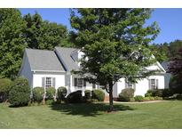 Charming single-story home with well-maintained lawn, mature trees and manicured landscaping at 70 Glen Oaks Drive Dr, Youngsville, NC 27596
