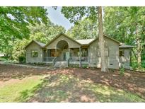 Inviting exterior showcasing the home's charming facade, complemented by mature trees and lush landscaping at 8821 Oconee Ct, Chapel Hill, NC 27516