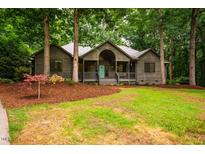 Charming home exterior featuring a landscaped front yard and a inviting covered front porch at 8821 Oconee Ct, Chapel Hill, NC 27516