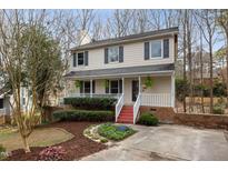 Charming two-story home with a welcoming front porch, red steps and landscaped yard at 905 Balmoral Dr, Cary, NC 27511