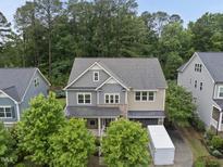 Charming two-story home with trees and a driveway featuring a white trailer for moving at 1029 Dozier Way, Cary, NC 27518