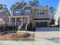Charming two-story home with a covered front porch and attached two-car garage and beautiful lawn at 1029 Dozier Way, Cary, NC 27518