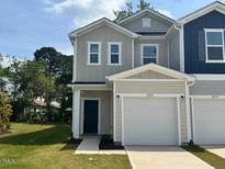 Charming two-story townhouse with neutral siding, attached garage, and well-manicured lawn at 10517 Brookside Reserve Rd, Raleigh, NC 27614