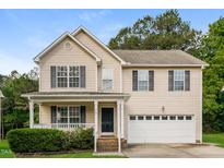 Traditional two-story home with a covered porch, manicured lawn and attached two car garage at 107 Kimeo Way, Garner, NC 27529