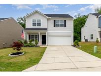 Charming two-story home with landscaped front yard and an attached two-car garage at 150 Sherrill Place Ln, Garner, NC 27529