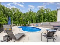 Inviting backyard pool area with mature trees, lounge chairs, and plenty of space for entertaining at 150 Sherrill Place Ln, Garner, NC 27529